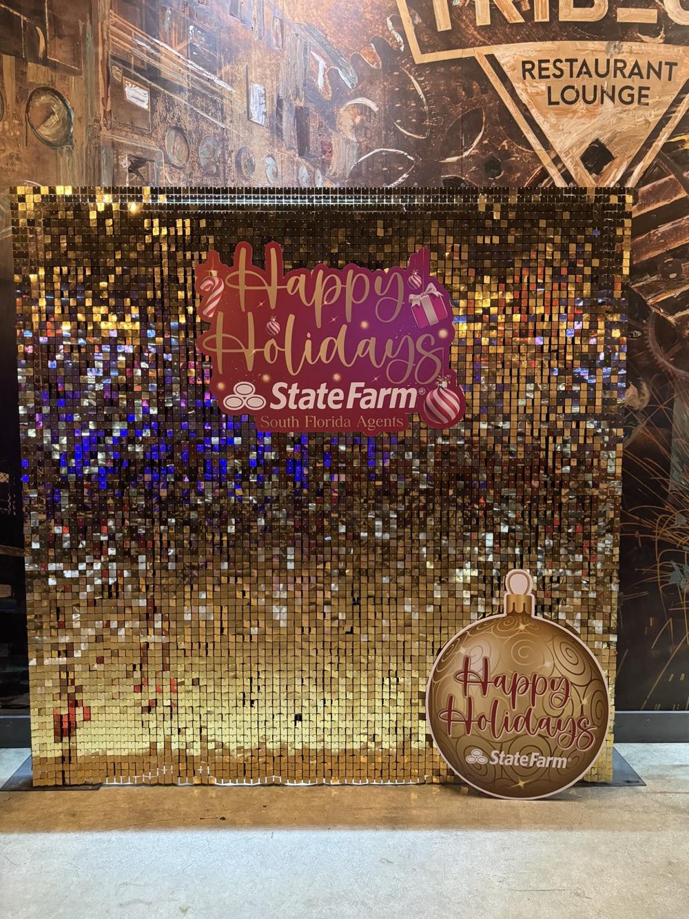Gold sequin photo wall with a Happy Holidays sign for State Farm South Florida Agents