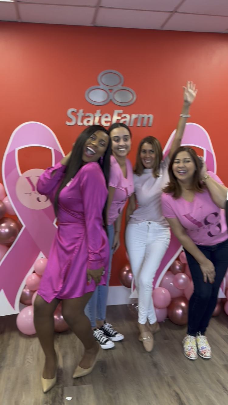 Agency team in pink posing in front of Pink October ribbon displays
